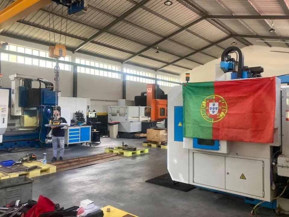 Interior da nave de produção com vários centros de maquinação alinhados e ponte rolante